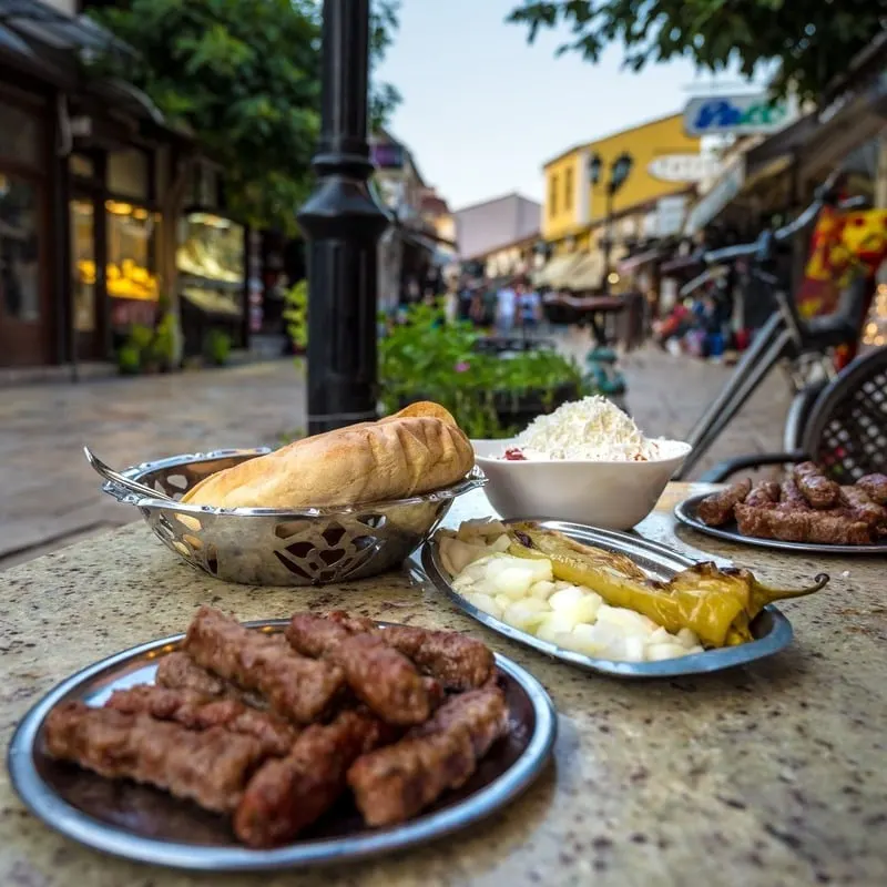 Cevapi On A Restaurant Table In Skopje, North Macedonia, A Traditional Dish Of The Balkan Peninsula In Eastern Europe