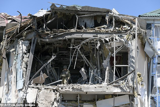 Military investigators work on the site of the damaged building housing the Paradise restaurant following a strike in Donetsk, Russian-controlled Ukraine, earlier this month