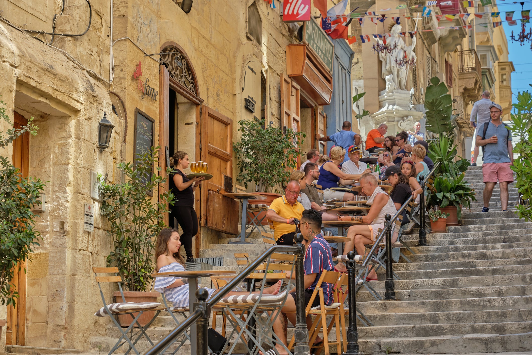 Enjoy parma pizzas from step-side rainbow chairs at San Paolo Naufrago