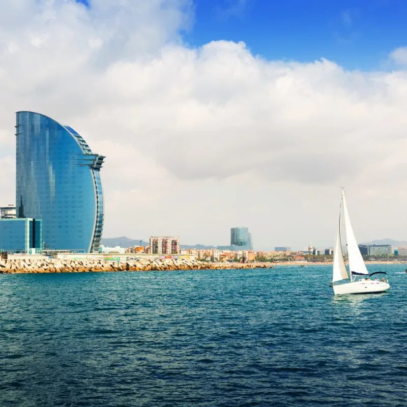 a sailing boat off the shore of port olimpic in barcelona spain