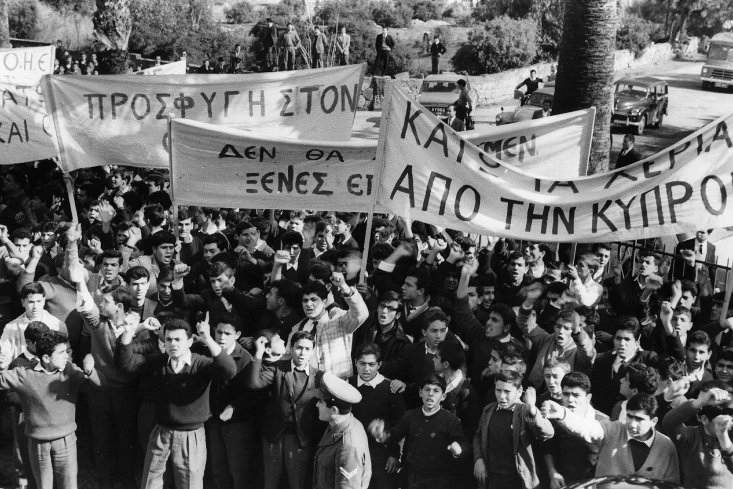 A crowd of Greek Cypriots participate in a communist-backed demonstration in this historic black-and-white image.
