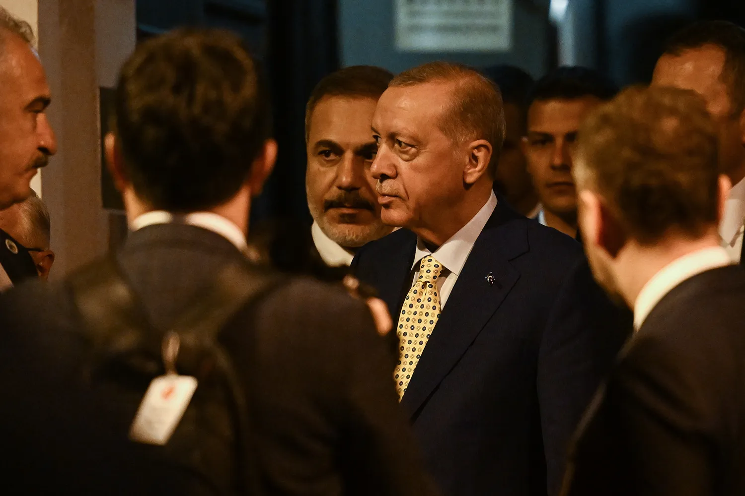 Turkish President Recep Tayyip Erdogan stands with members of his security detail in a crowded room at a NATO summit in Lithuania.