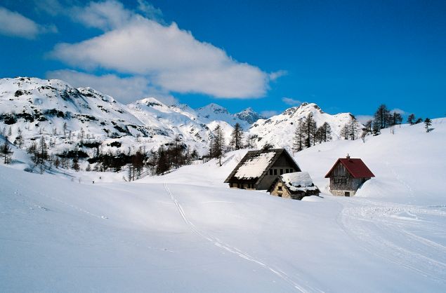 Image: Mountain huts and snow covered mountains in Vogel, Slovenia.