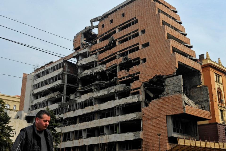 A man walks past the building of former federal military headquarters in Belgrade on March 24, 2010, destroyed during the 1999 NATO air campaign against Yugoslavia. AFP via Getty Images