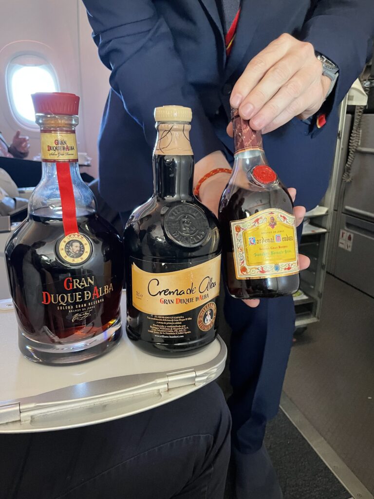 A cabin crew member show off a selection of liquors 