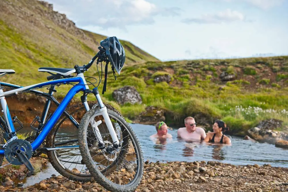 Parked bikes and people bathing in natural spring in Iceland — Getty Images