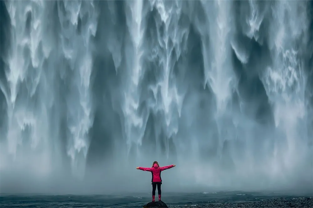 Person stood in front of waterfall in Iceland — Shutterstock