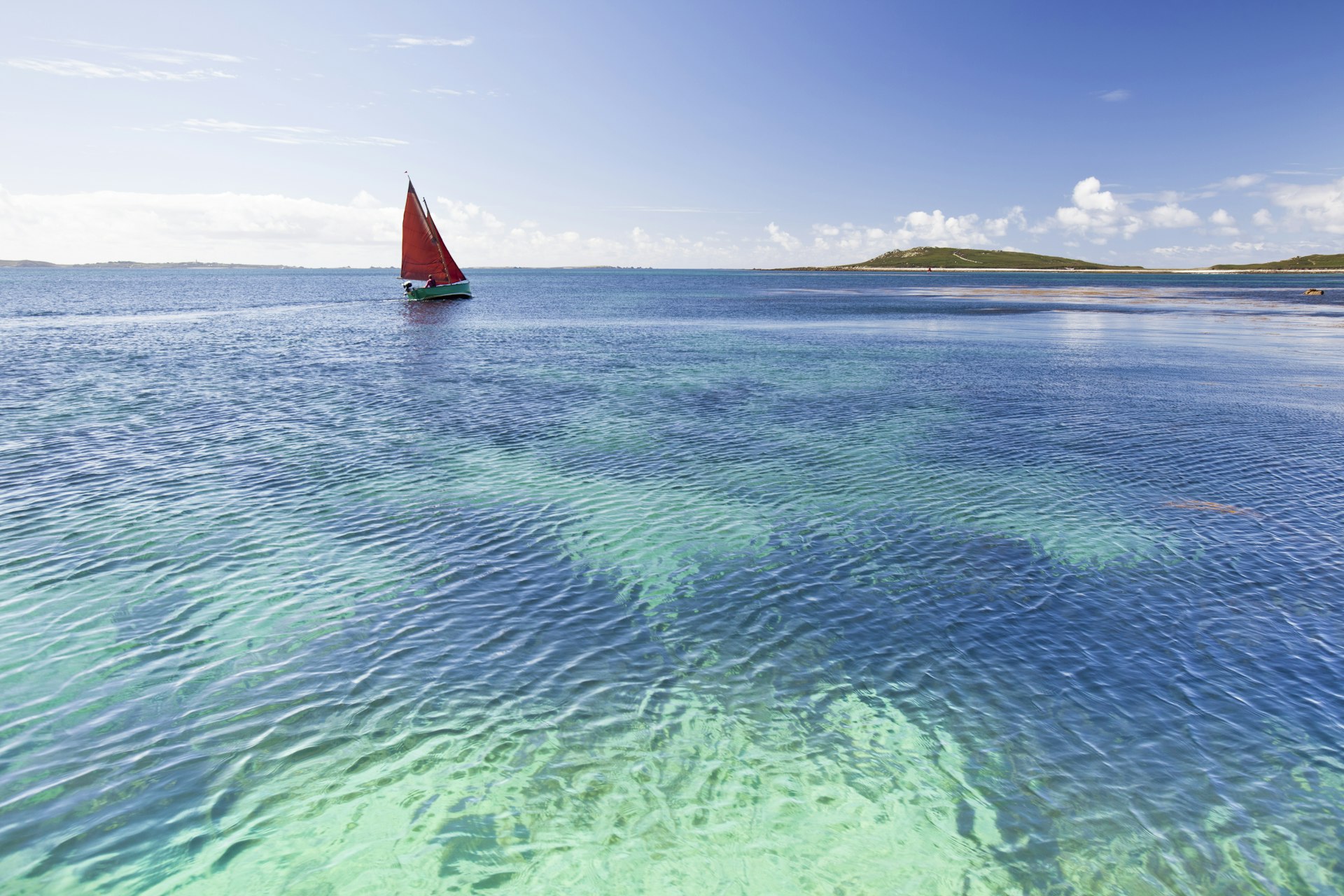 Yacht sailing on turquoise waters.