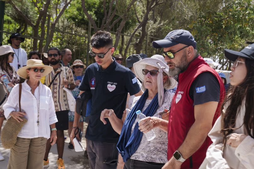 A tourist is helped by First Aid personnel from ancient Acropolis site, in central Athens, Wednesday, 12 June, 2024. 