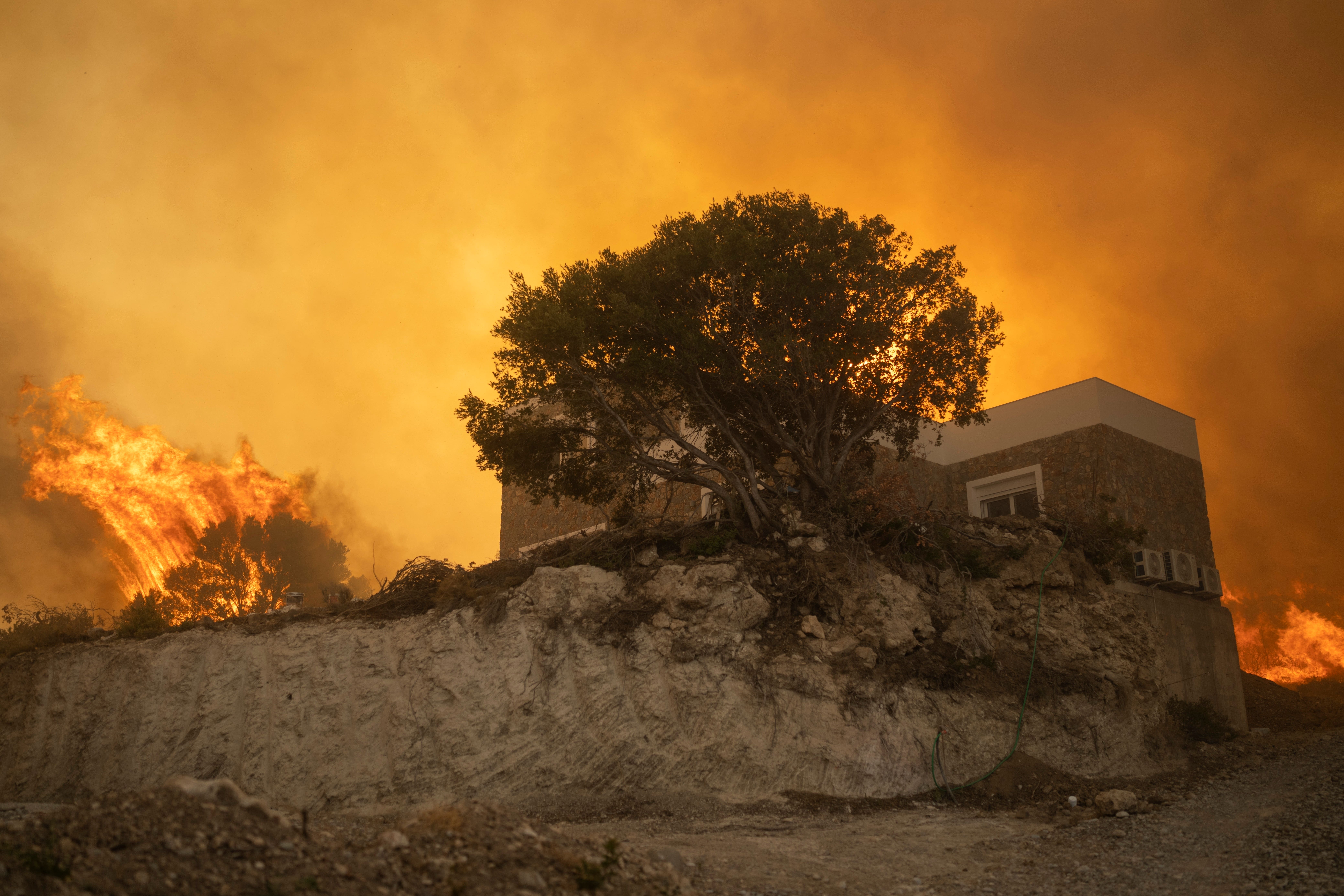 A wildfire burns in Gennadi village, on the Greek island of Rhodes in July 2023 (Petros Giannakouris/AP/PA)