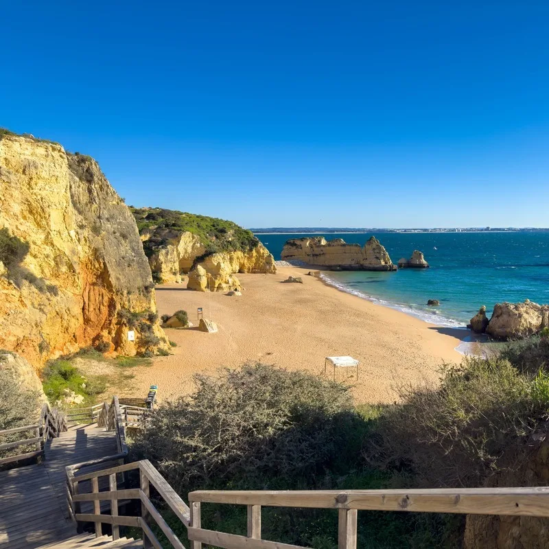Wooden Staircase Leading Down To Praia Dona Ana Beach, Bounded By The Atlantic Coast, Southern Portugal, Southern Europe