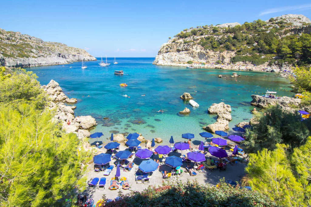 Gorgeous Beach In Rhodes Bounded By Turquoise Mediterranean Waters In The Dodecanese Group Of Islands In Greece, Southern Europe