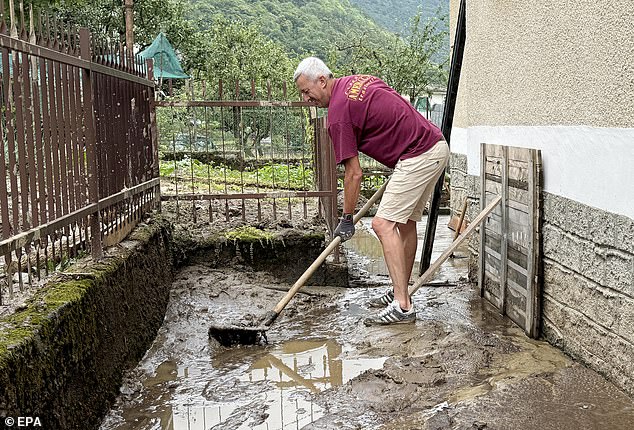 A resident works to clean an area damaged by flooding in Chialamberto, Lanzo Valley, near Turin, Italy, June 30
