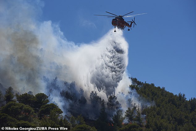 Firemen and helicopters try to control a large wildfire in Keratea. Many homes were evacuated and houses were burnt during the wildfire that took place in Keratea, an area south of Athens