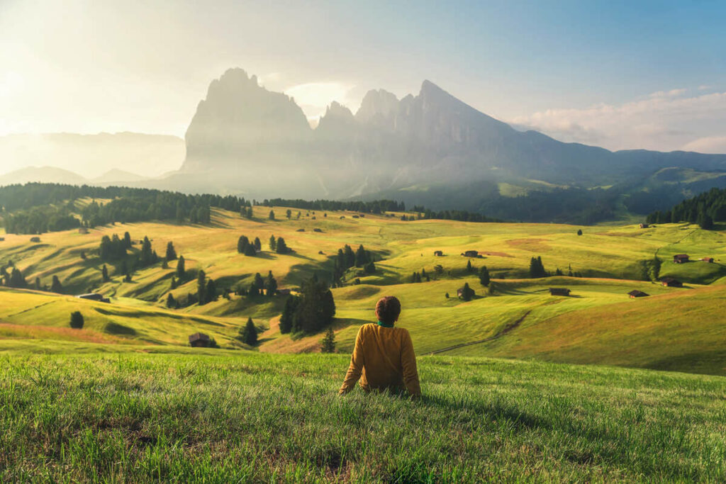 Young Woman Sat In A Viewpoint Overlooking The Dolomites In South Tyrol, Italy