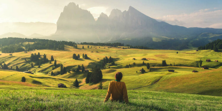 Young Woman Sat In A Viewpoint Overlooking The Dolomites In South Tyrol, Italy