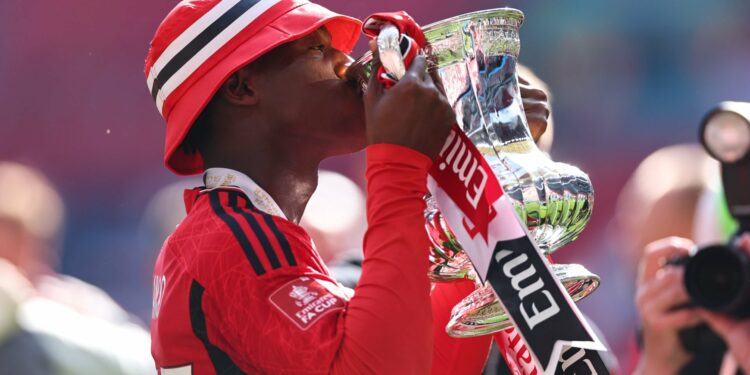 Kobbie Mainoo of Manchester United kisses the FA Cup Trophy at full time as Manchester United win the 2024 Emirates FA Cup during the Emirates FA C...