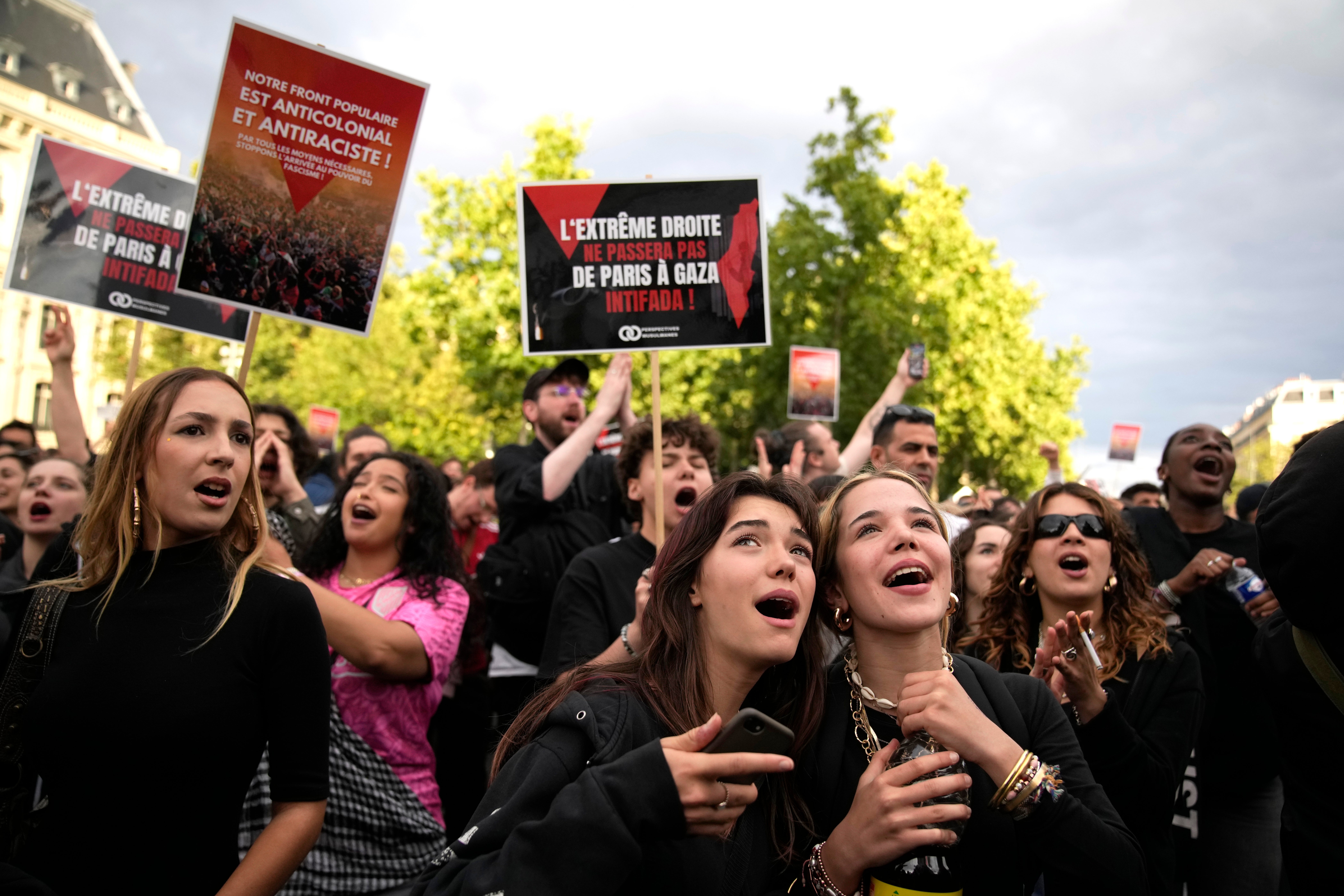 People react to the projection of results during the second round of the legislative elections, near Republique Plaza in Paris, France, Sunday, 7 July 2024