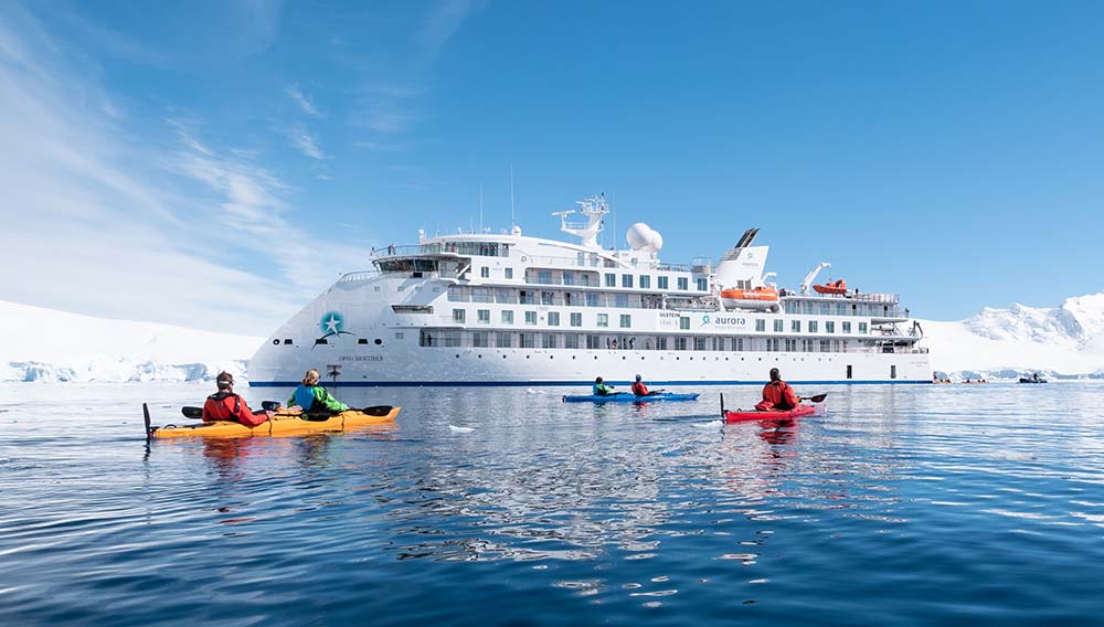 Aurora Expeditions kayaking around ship in Antarctica for travel deals