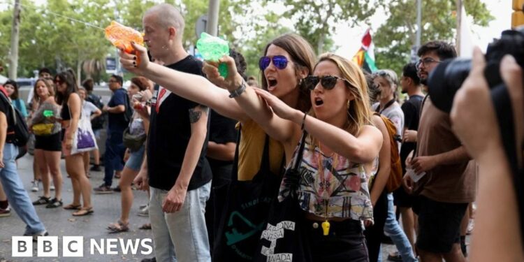 Mass tourism protesters squirt water at Barcelona tourists