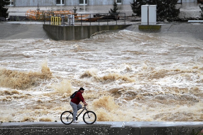 Man cycles past floodwaters 