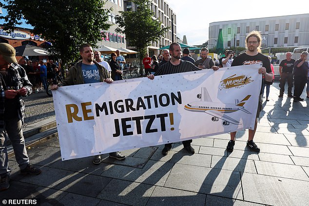 Far-right protesters hold a banner reading 'Remigration now' as they march through the streets of Solingen, following a stabbing rampage, on August 26