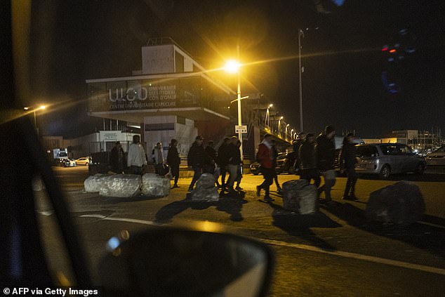 Migrants walk as they prepare to attempt a crossing of the English Channel near the beach of Boulogne-sur-Mer, northern France on September 21, 2024