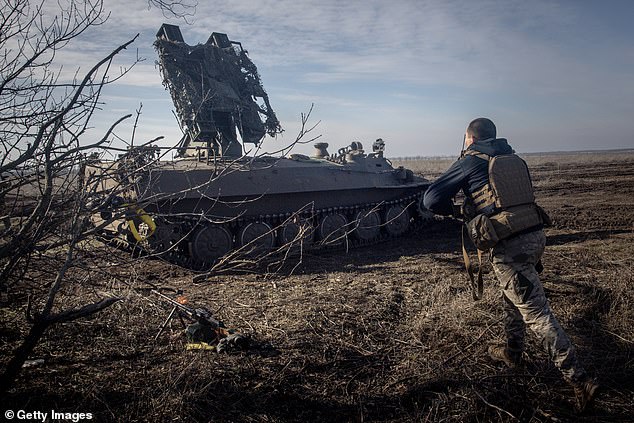 A member of Ukraine's 72nd Brigade Anti-air unit runs to a position as they prepare to fire a Strela -10 anti-air missile system after sighting a Russian drone