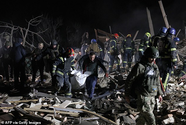 Ukrainian police officers and rescuers carry the body of a local resident killed in a Russian rocket attack in Kramatorsk, Donetsk region, on February 17, 2024