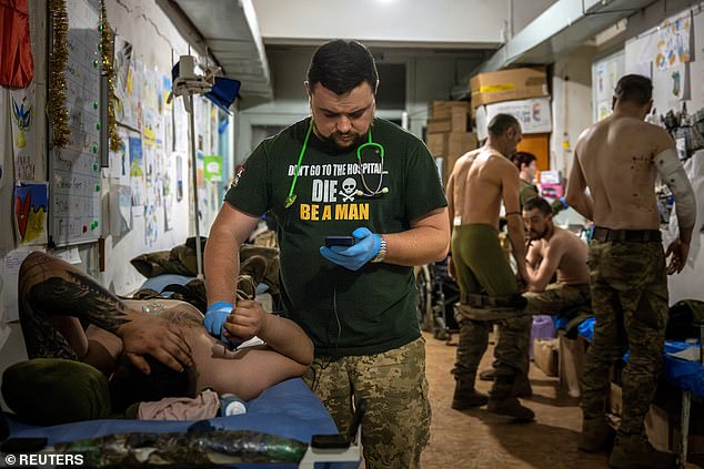 Volodymyr, a doctor at a medical stabilisation point near the frontlines, checks on a patient, amid Russia's attack on Ukraine, in the Donetsk region, Ukraine, April 15, 2024