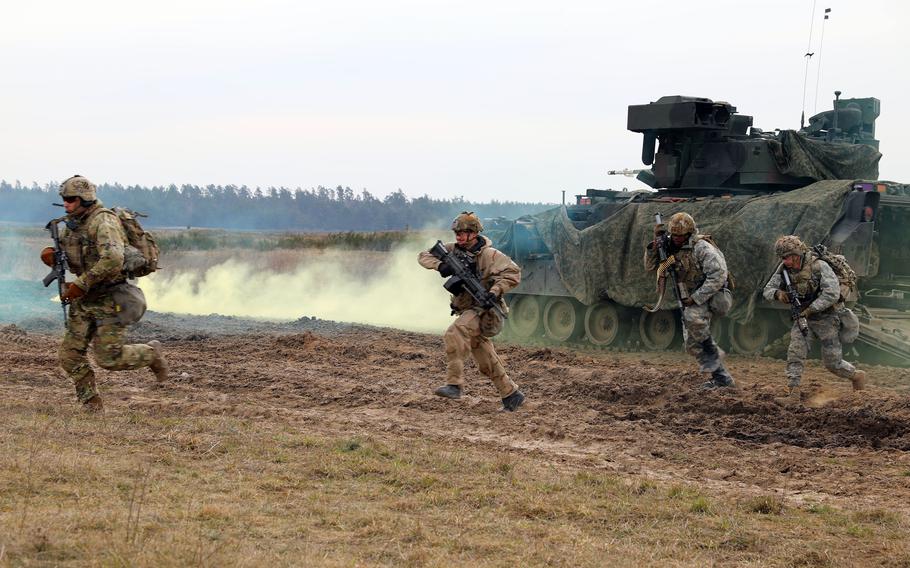 Soldiers assigned to 2nd Armored Brigade, 3rd Infantry Division run toward a defensive position during an exercise at Bemowo Piskie Training Area in Poland on March 11, 2024. 