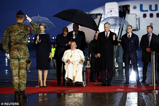 The King, Queen and Pope were saluted by a member of the  Belgian military as they stood on the red carpet