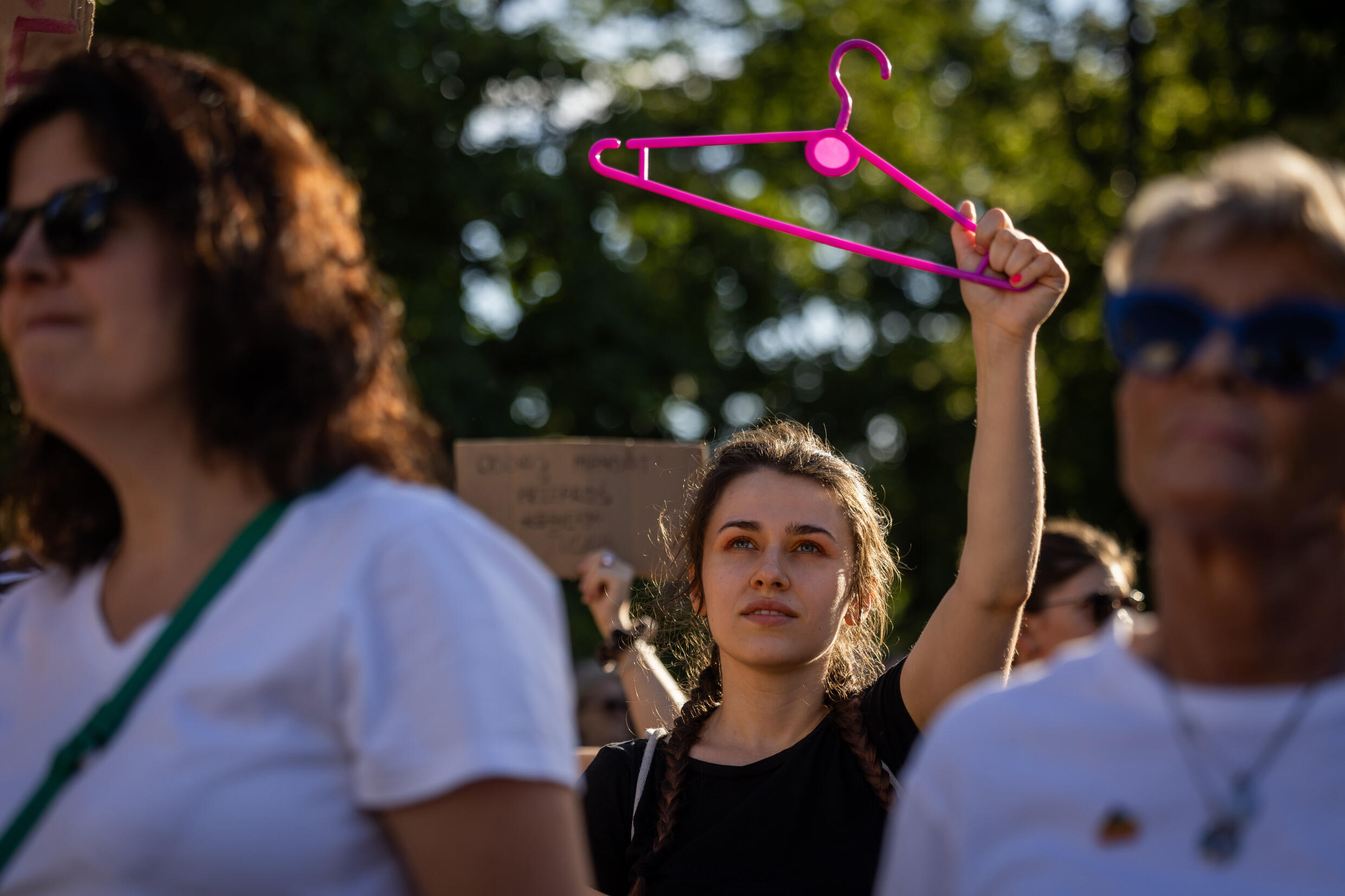 A demonstrator holds a hanger to symbolise backstreet abortions at a rally in Warsaw, Poland in July 2024