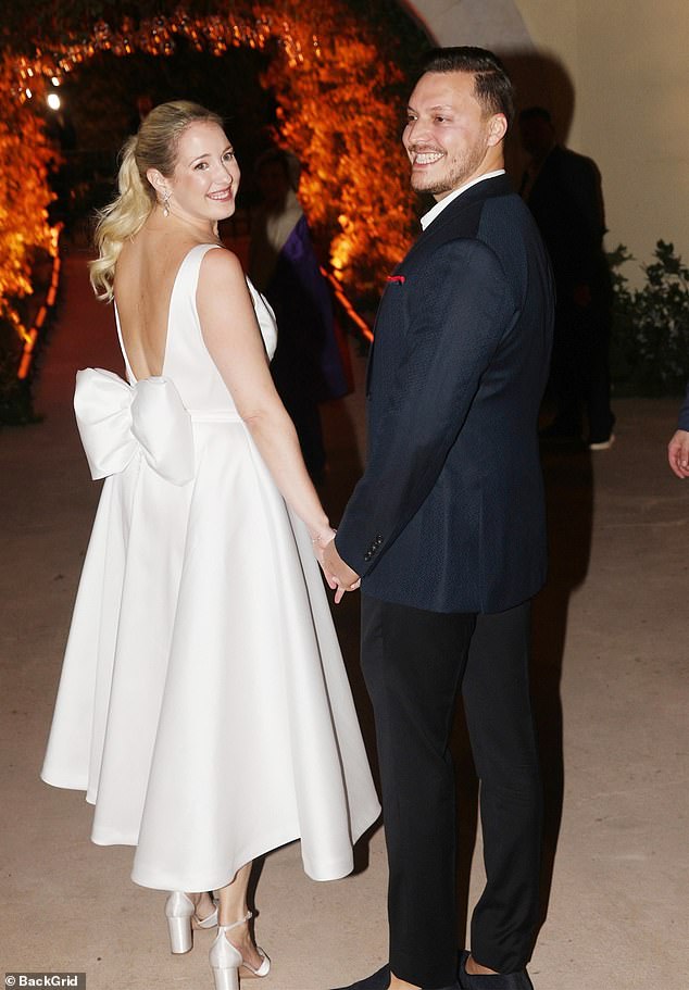 Looking effortlessly elegant, the bride teamed her dress with a pair of matching white heels and the $373 ¿Elos¿ Box Clutch in Pearl from Los-Angeles based brand Cult Gaia