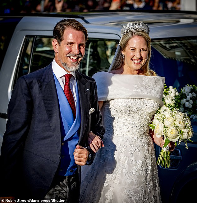 Crown Prince Pavlos and Crown Princess Theodora prepare to head into the church as she stuns with a stunning floral wedding gown and an equally gorgeous smile