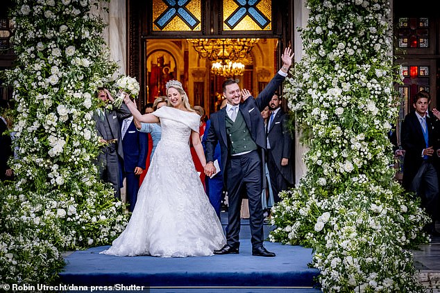 The blushing bride and her dashing groom wave to the hoards of supporters outside the cathedral