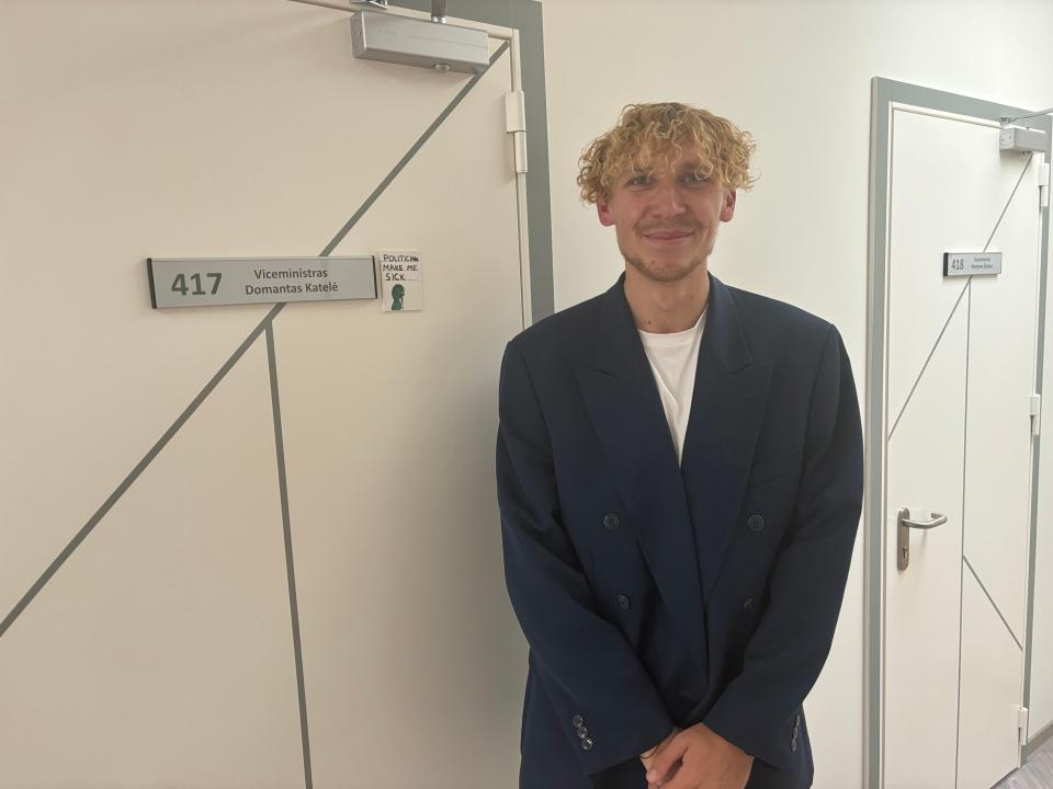 Domantas Katelė in front of his office door