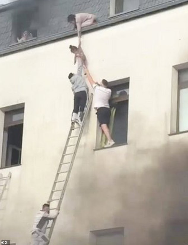 Neighbours tried to reach up with ladders to help people escape, but they weren't long enough to reach the upper floors so brave residents worked together to lower children from the roof