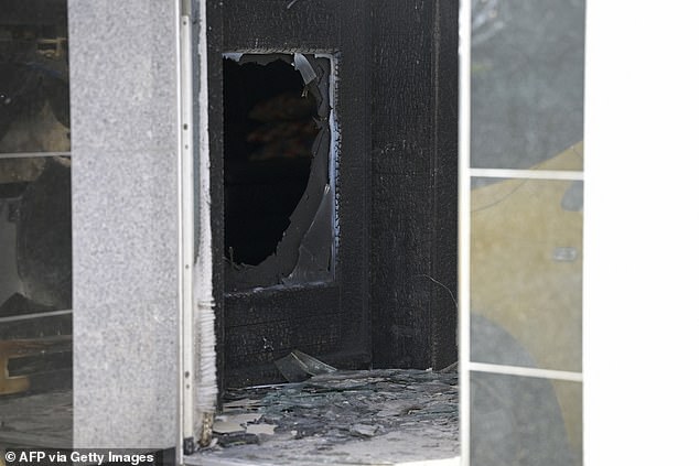 The damaged entrance door of a commercial and apartment building is pictured in Essen