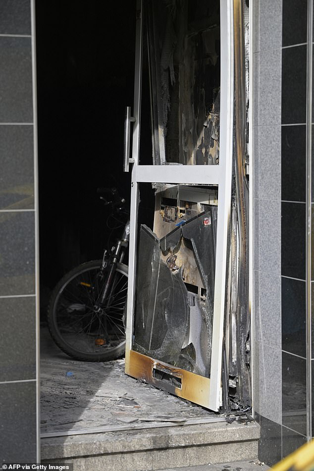 A destroyed entrance door of a commercial and apartment building is pictured in Essen