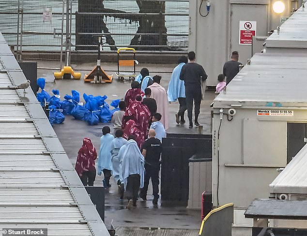 Migrants wrapped in towels after they were picked up in the English Channel by British Border Force on September 22