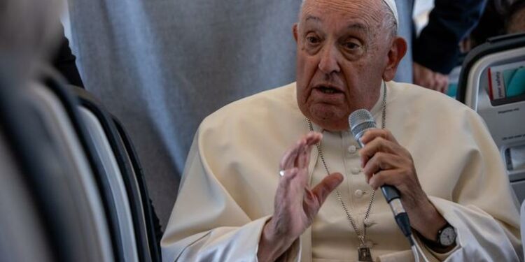 Pope Francis speaks aboard the papal plane on Sept. 29.