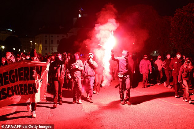 Protesters light flares in a demonstration in Vienna, after the exit poll showing a win for the far-right Freedom Party