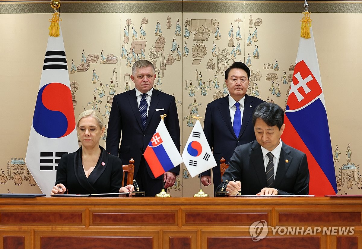 Ahn Duk-geun (R, seated), the South Korean minister of trade, industry and energy, and Denisa Sakova, the Slovak deputy prime minister and minister of economy (L, seated), sign memoranda of understanding on the Trade and Investment Promotion Framework and a comprehensive energy cooperation at the presidential office in Seoul on Sept. 30, 2024. President Yoon Suk Yeol (R, standing) and Slovak Prime Minister Robert Fico attend the signing ceremony. (Pool photo) (Yonhap)