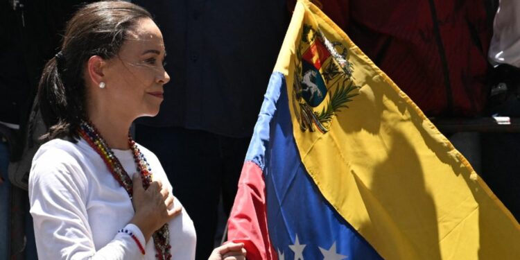 Venezuelan opposition leader María Corina Machado holds a Venezuelan national flag as she gestures from atop a truck during a demonstration to protest over the presidential election results, in Caracas on August 3, 2024.