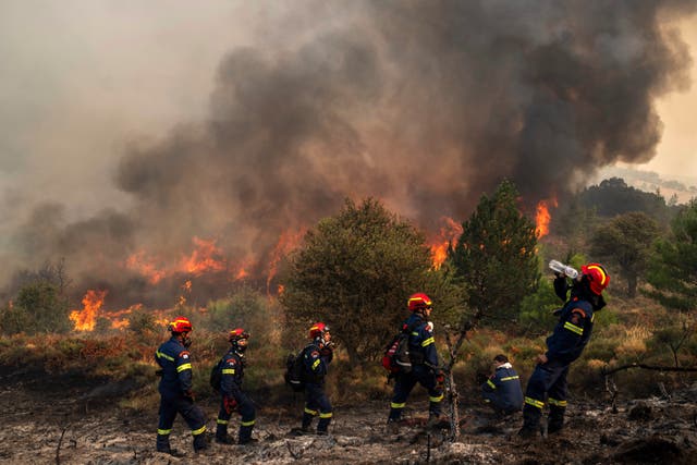 A firefighter drinks water during a third day of a wildfire in Sofiana village