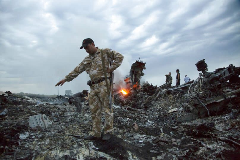 In this July 17, 2014, file photo, people walk amongst the debris at the crash site of MH17 passenger plane near the village of Grabovo, Ukraine, that left 298 people killed.