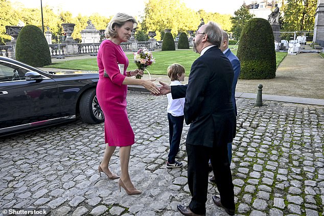 The Queen walked expertly on the cobbled paving in stilettos as she shook the hand of a delegate at the conference