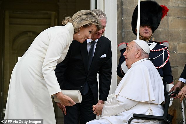 Queen Mathilde cut a stylish figure in a crisp snow coloured dress, not a dissimilar to the pope's own white regalia