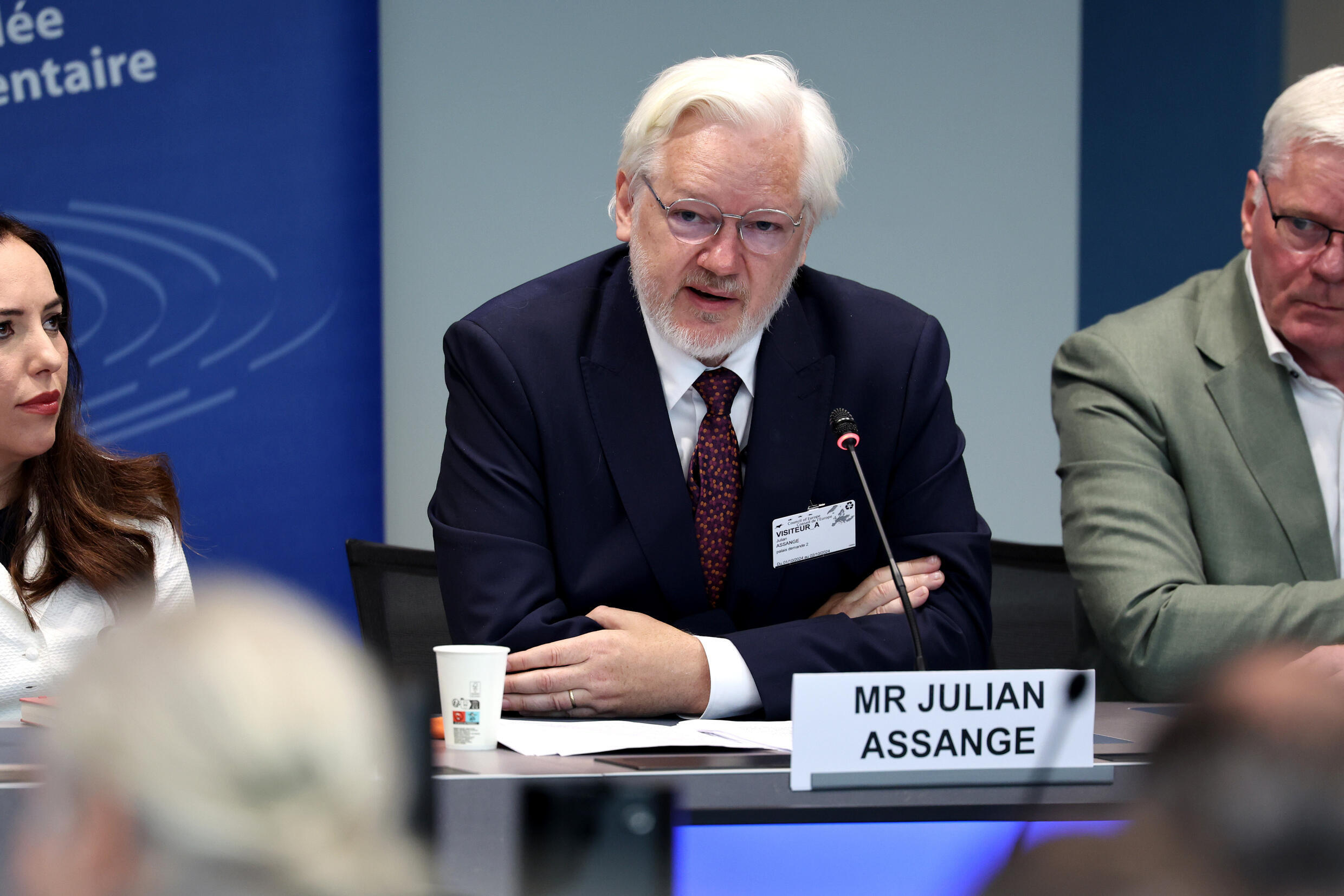 Julian Assange speaks to journalists after a parliamentary hearing in Strasbourg